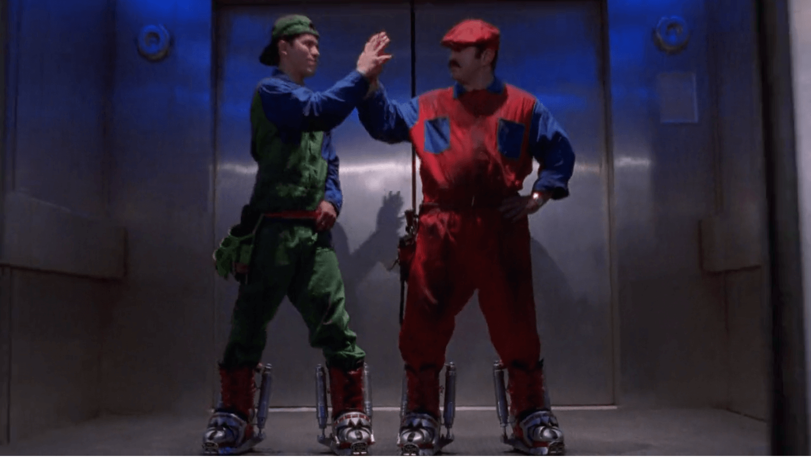 Karakter Mario dan Luigi sedang tos bersama, masing-masing memakai overall hijau dan merah